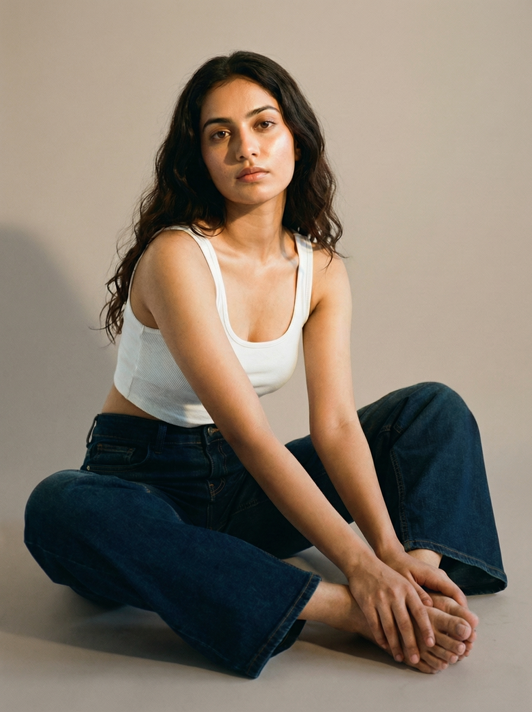 Woman sitting cross-legged wearing Nova Afterlight Indigo Jeans