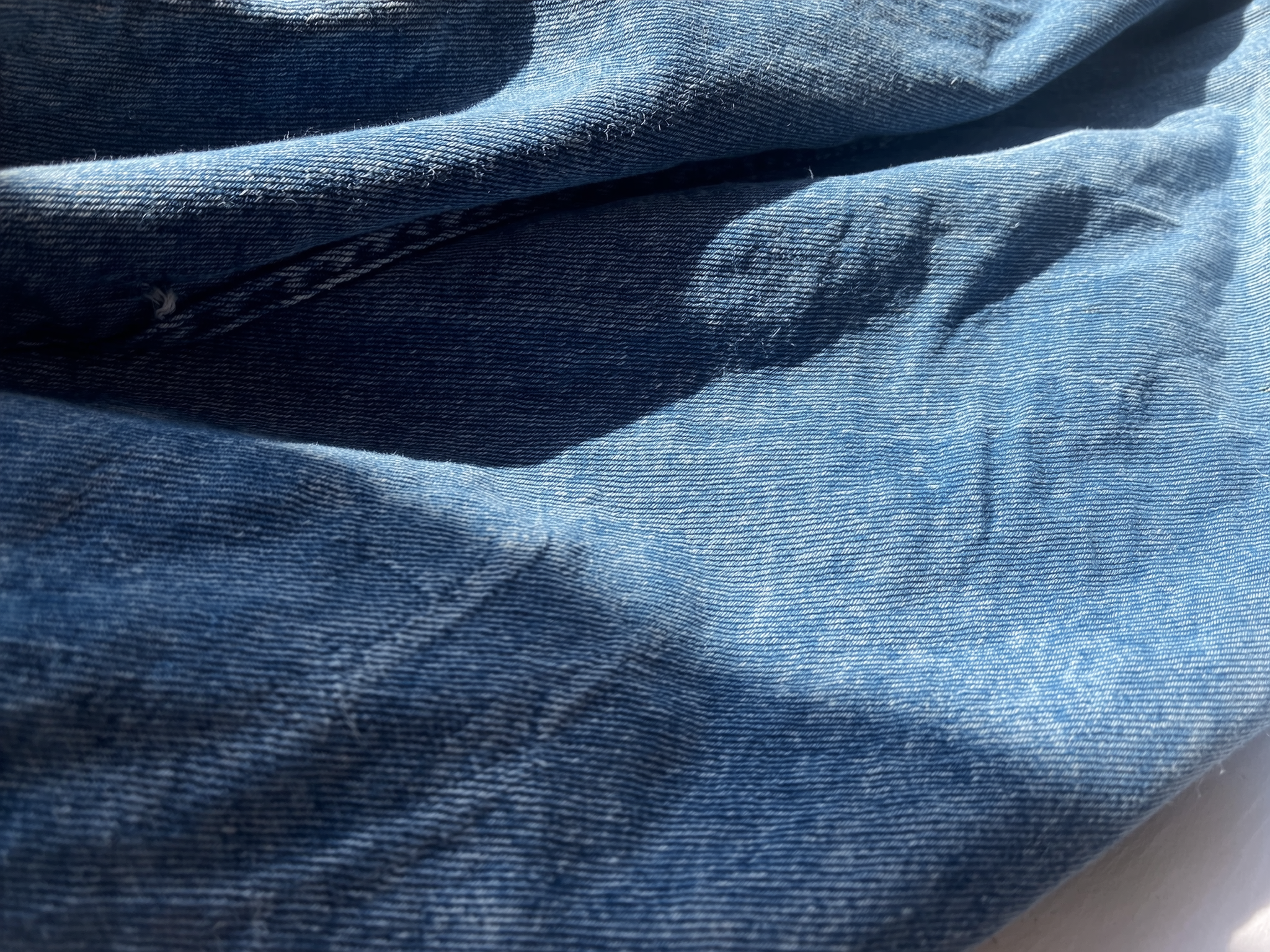 Close-up of SOH's blue denim fabric with visible stitching