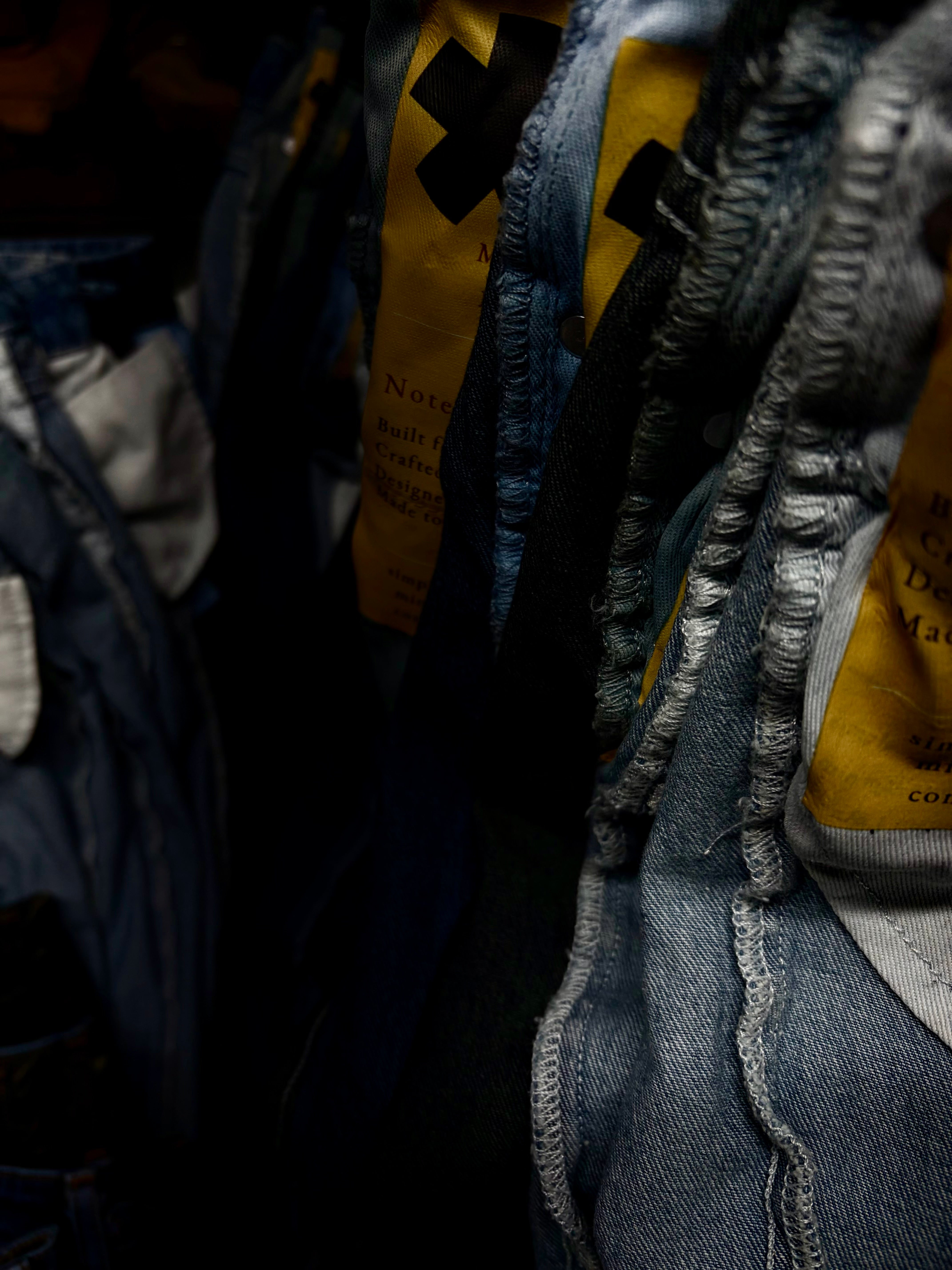 Close-up of a SOH denim jeans with brand labels on a dark background