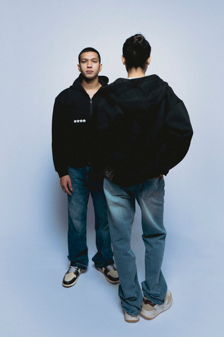 Two people wearing SOH Hoodie Error 01 and jeans standing against a light blue background