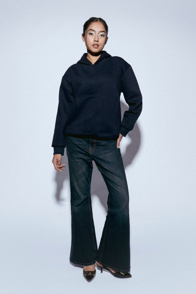 Person wearing a SOH Hoodie Error 02 and SOH jeans on a white background