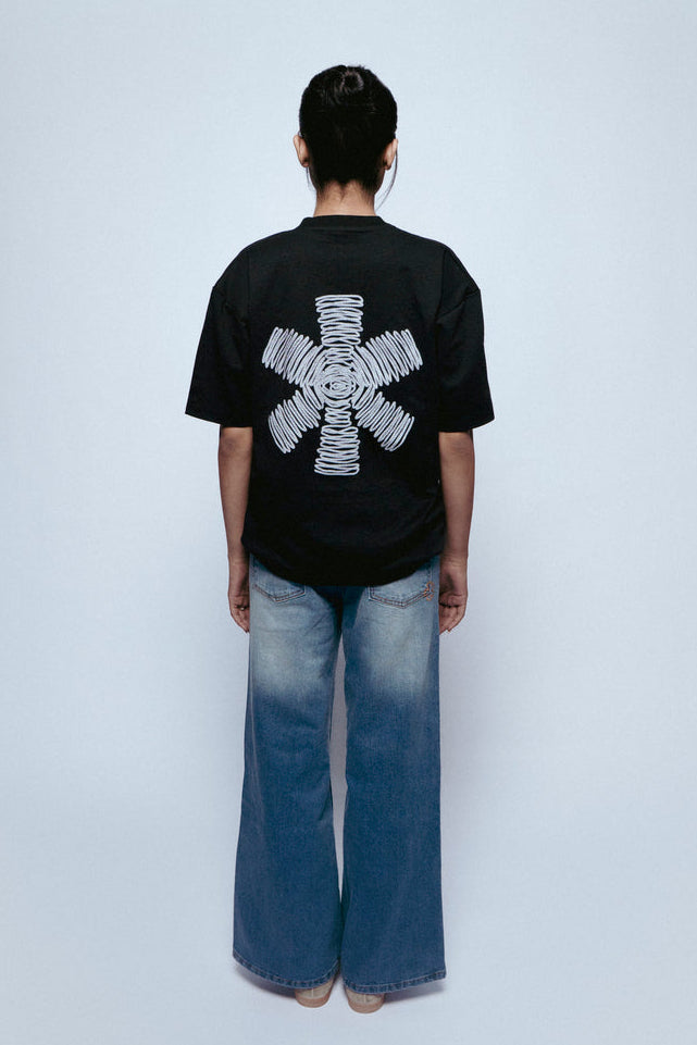Person wearing a black SOH Mark T-shirt with a white design on the back, standing against a plain background.