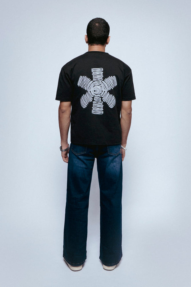 Person wearing a black SOH Mark T-shirt with a white graphic design on a plain background