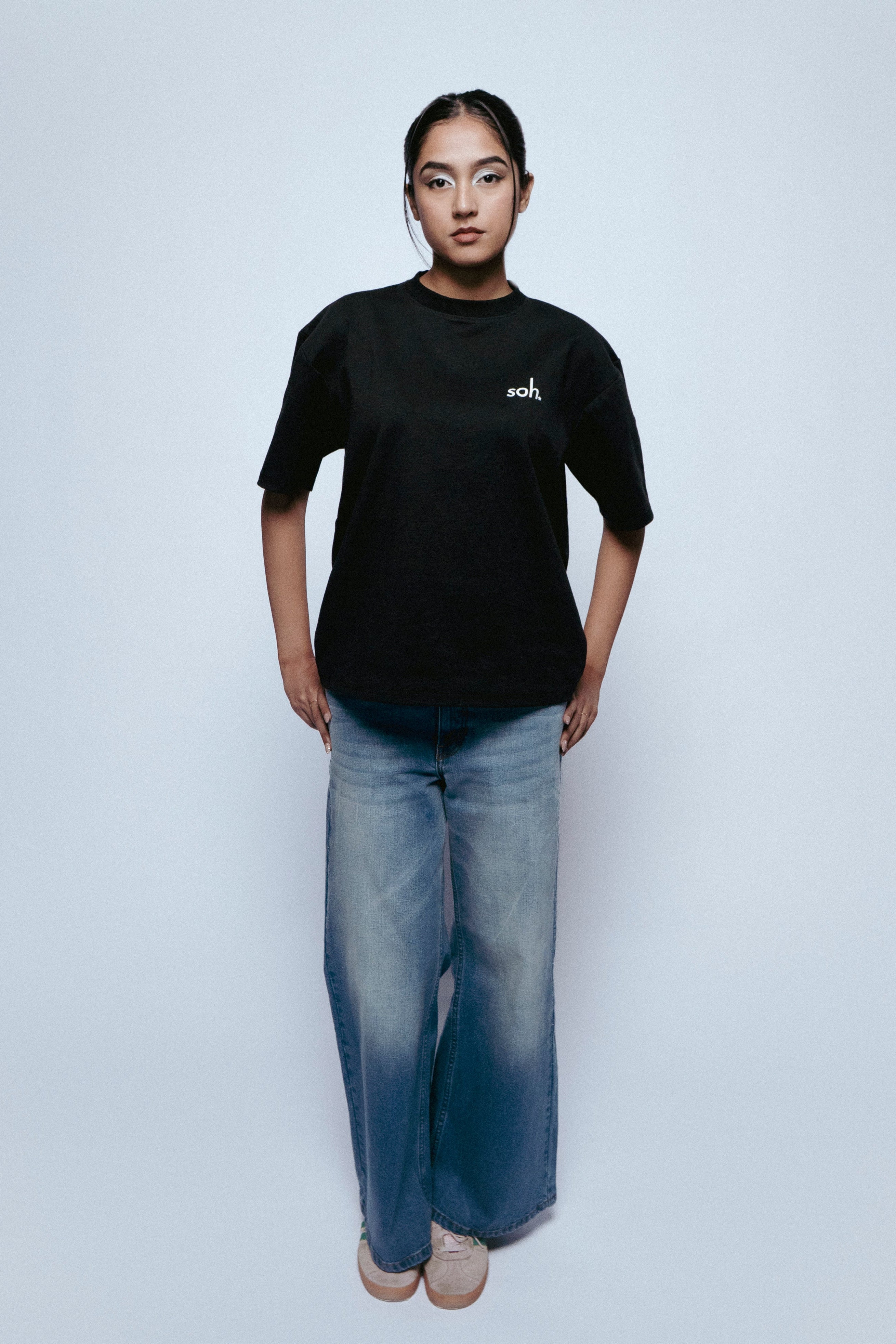 Person wearing a black SOH MARK t-shirt and SOH Nova jeans on a white background