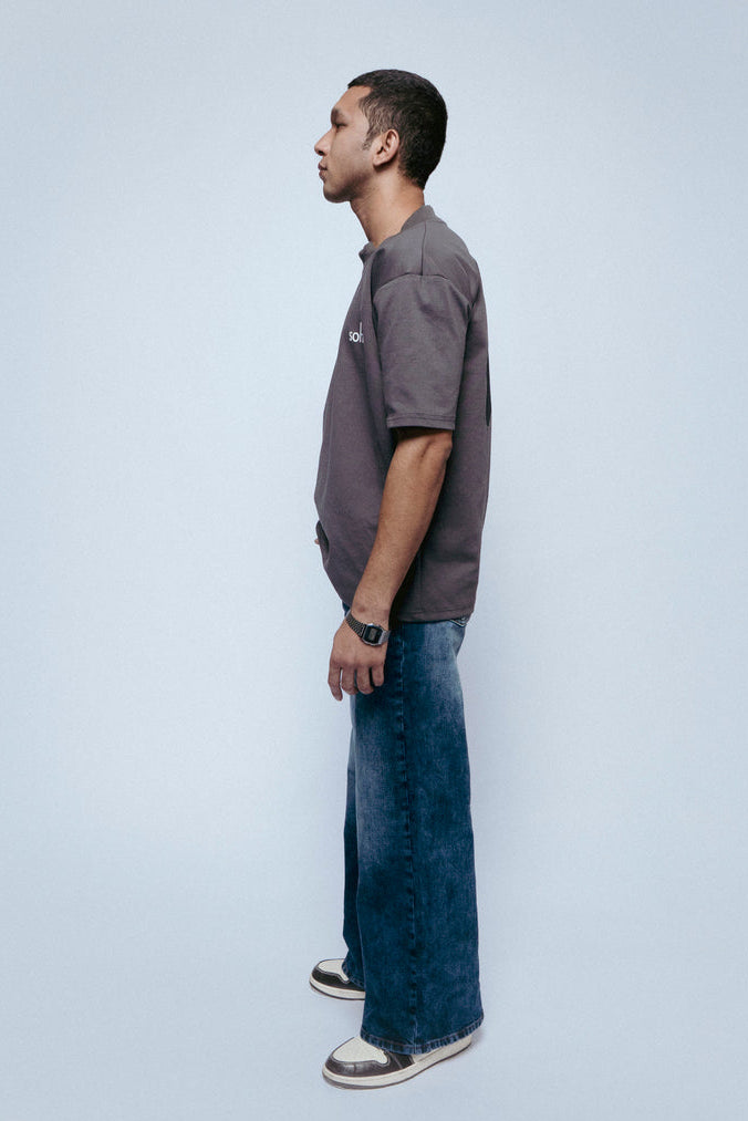 Man standing in profile wearing SOH Question T-shirt